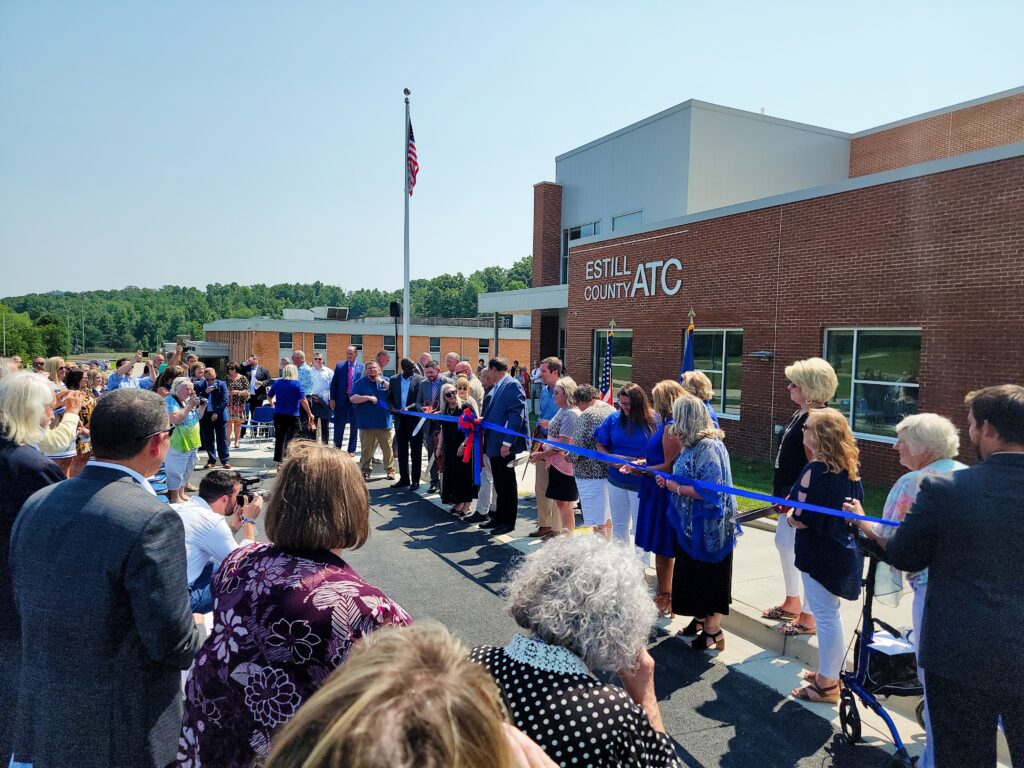 A crowd of people at a ribbon cutting ceremony.