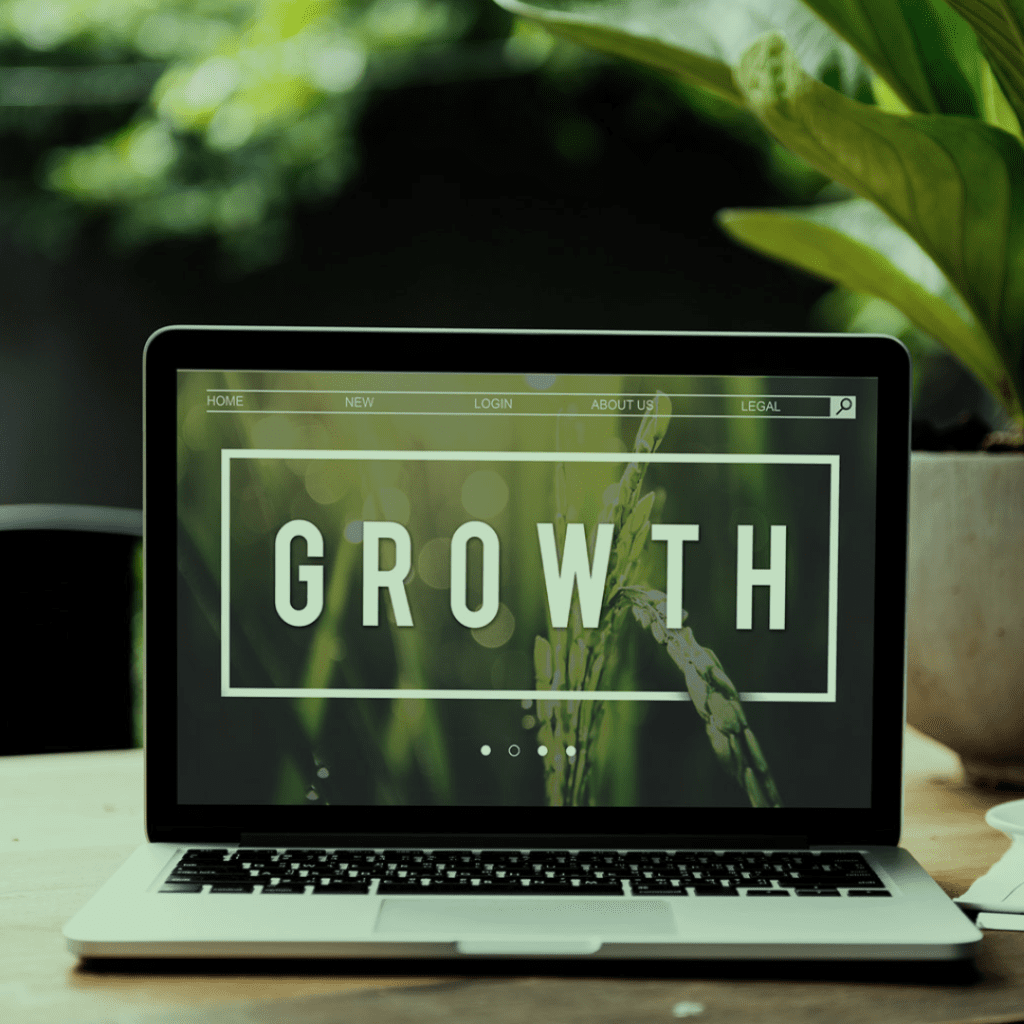 A laptop with the word growth on it on a wooden table.